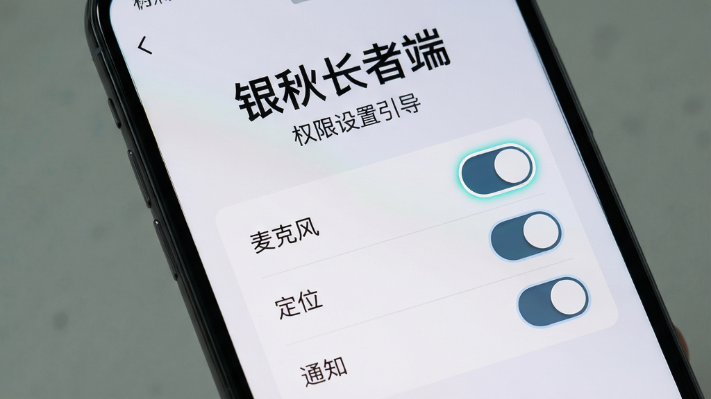 画面主体为一部手机屏幕特写,显示“银秋长者端”权限设置引导页面,布局为顶部大号说明文字与下方逐项权限开关(麦克风、定位、通知),风格为简洁明了的步骤引导风,细节上开关按钮带高亮描边、背景为浅灰渐变,画质高清,干净无多余元素